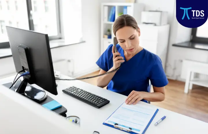Nurse coordinating patient information over the phone using a digital management system in a large healthcare facility